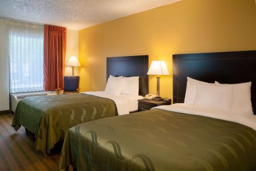 a hotel room with two beds and two lamps at Quality Inn at Arlington Highlands in Arlington