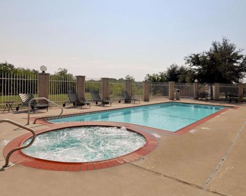 a swimming pool with chairs around it at Comfort Suites Roanoke - Fort Worth North in Roanoke