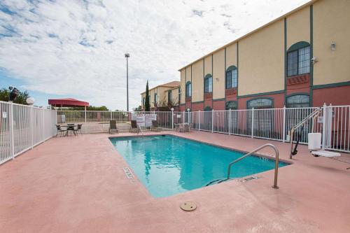a swimming pool in front of a building at Quality Suites in Temple