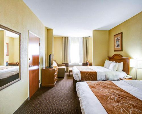um quarto de hotel com duas camas e uma televisão em Comfort Suites em Brenham