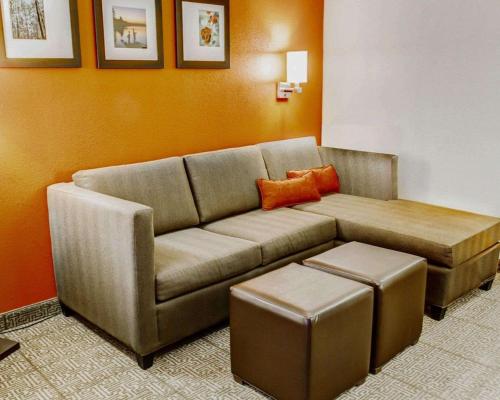 a living room with a brown couch and stool at Comfort Suites Tyler South in Tyler