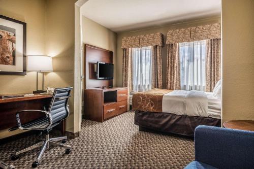 um quarto de hotel com uma cama, uma secretária e uma cadeira em Comfort Suites Near Texas State University em San Marcos