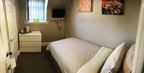 um pequeno quarto com uma cama e uma janela em Micklegate House em Selby