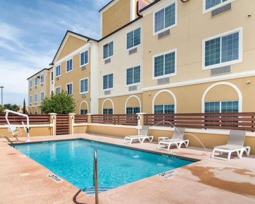 a swimming pool in front of a building at Comfort Suites Odessa near University in Odessa
