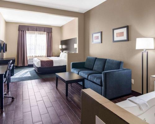 a hotel room with a couch and a bed at Comfort Suites Odessa near University in Odessa
