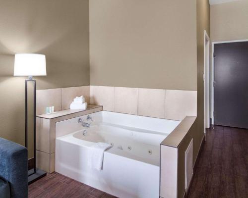a large white tub in a room with a lamp at Comfort Suites Odessa near University in Odessa