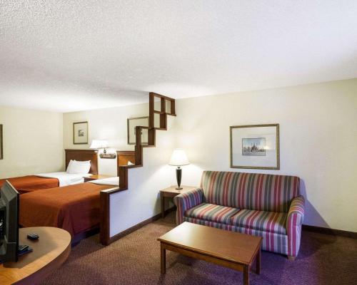 a hotel room with a bed and a couch at Rodeway Inn & Suites South of Fiesta Park in San Antonio