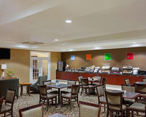 a restaurant with tables and chairs and a bar at Comfort Suites University in Abilene