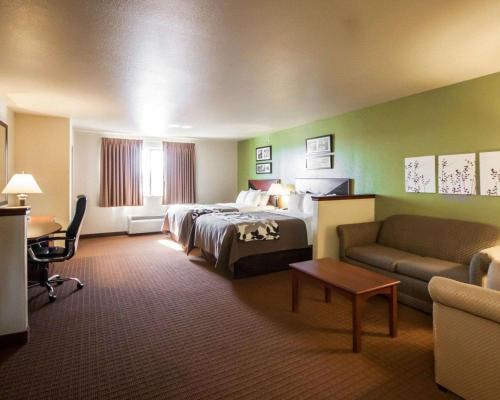 a hotel room with a bed and a couch at Sleep Inn & Suites in Shamrock