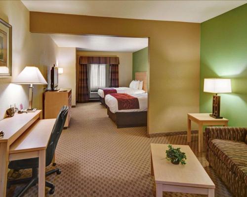 a hotel room with a bed and a couch at Comfort Suites Lindale in Lindale