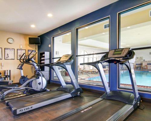 a gym with two exercise bikes and a swimming pool at Comfort Suites Fort Stockton in Fort Stockton