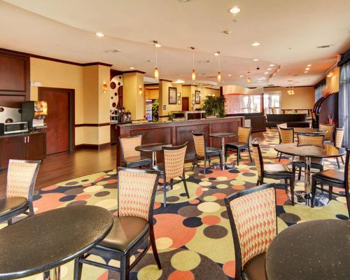 a restaurant with tables and chairs on a rug at Comfort Suites Kilgore in Kilgore