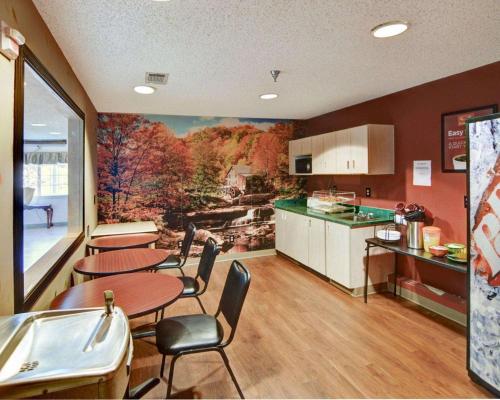 a kitchen with tables and chairs and a painting on the wall at Rodeway Inn & Suites Lewisville I-35 in Lewisville