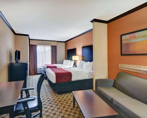 a hotel room with two beds and a couch at Comfort Suites Kilgore in Kilgore