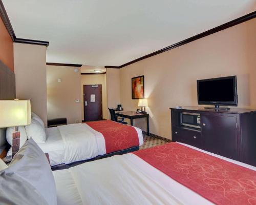 a hotel room with two beds and a flat screen tv at Comfort Suites Kilgore in Kilgore