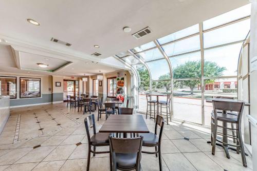 a dining room with tables and chairs and windows at Quality Inn Allen - Plano East in Allen
