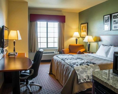 a hotel room with a bed and a desk at Sleep Inn & Suites at Six Flags in San Antonio