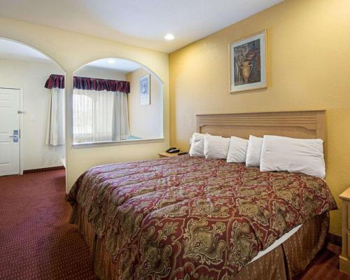 a bedroom with a large bed in a room at Scottish Inn & Suites IAH West in Westfield