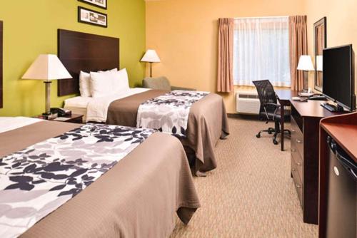 a hotel room with two beds and a desk at Sleep Inn and Suites Downtown Houston in Houston