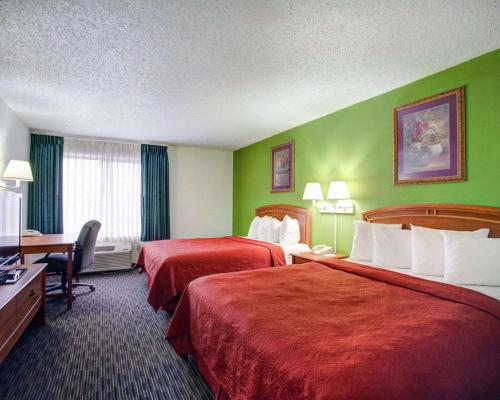 a hotel room with two beds and green walls at Hotel Del Valle - Austin SE by IHG in Austin