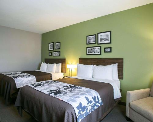 a hotel room with two beds and a chair at Sleep Inn & Suites Round Rock - Austin North in Round Rock