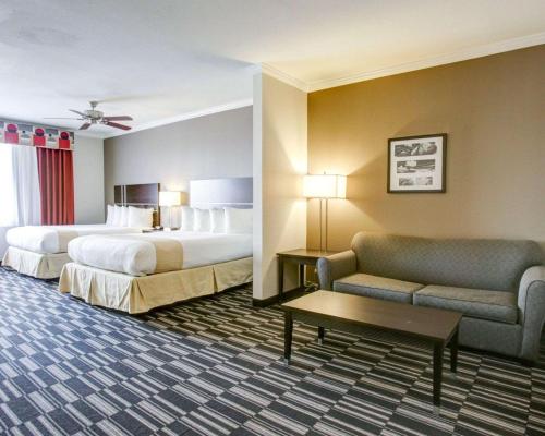 a hotel room with two beds and a couch at Quality Inn & Suites in Bryan