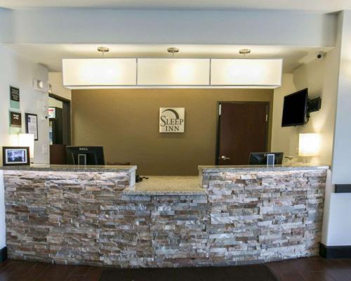 a lobby of a hotel with a stone wall at Sleep Inn & Suites Round Rock - Austin North in Round Rock