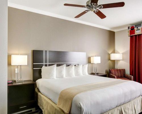 a large bed in a hotel room with a ceiling fan at Quality Inn & Suites Bryan-College Station in Bryan