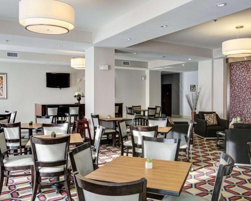 a restaurant with tables and chairs and a television at Quality Inn & Suites Bryan-College Station in Bryan