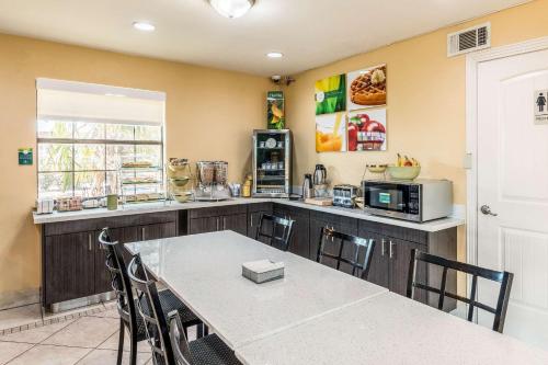 a kitchen with a table with chairs and a microwave at Quality Inn Corsicana in Corsicana