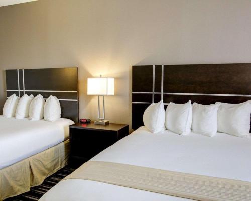 a hotel room with two beds with white pillows at Quality Inn & Suites Bryan-College Station in Bryan