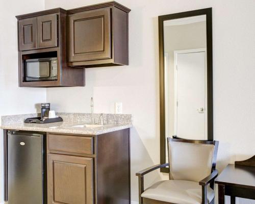 a kitchen with a counter and a sink and a chair at Quality Inn & Suites Bryan-College Station in Bryan