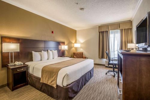 Habitación de hotel con cama grande y escritorio. en Quality Inn and Suites Seabrook - NASA - Kemah en Seabrook