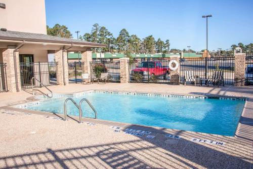 a swimming pool in front of a building at Sleep Inn & Suites Center in Center