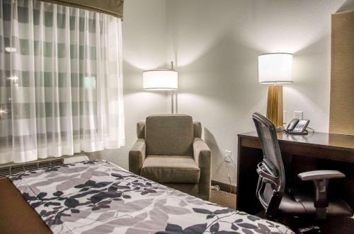 a hotel room with a bed and a desk and a chair at Sleep Inn & Suites Center in Center