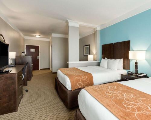a hotel room with two beds and a flat screen tv at Comfort Suites at Katy Mills in Katy