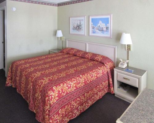 Habitación de hotel con cama con manta roja en Rodeway Inn San Juan, en San Juan