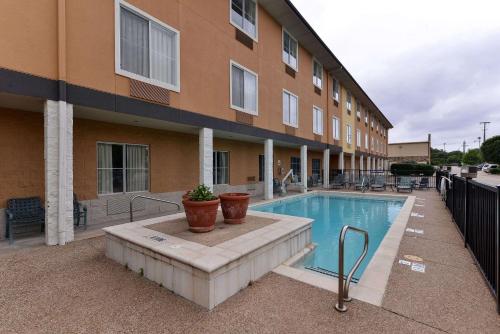 a building with a swimming pool in front of a building at Comfort Inn & Suites Frisco - Plano in Frisco