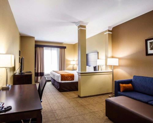 Habitación de hotel con cama y sofá en Comfort Suites Northwest - Cy - Fair, en Houston