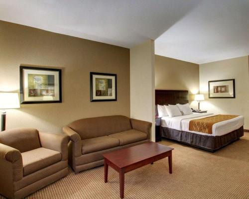 a hotel room with a bed and a couch and a table at Comfort Inn & Suites in Alvarado
