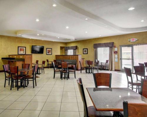 a dining room with tables and chairs and a television at Comfort Inn & Suites in Alvarado