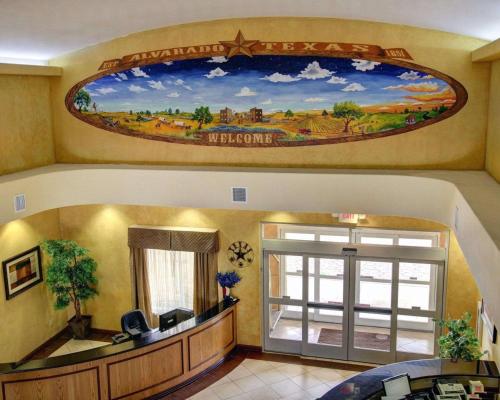 a living room with a mural on the wall at Comfort Inn & Suites in Alvarado