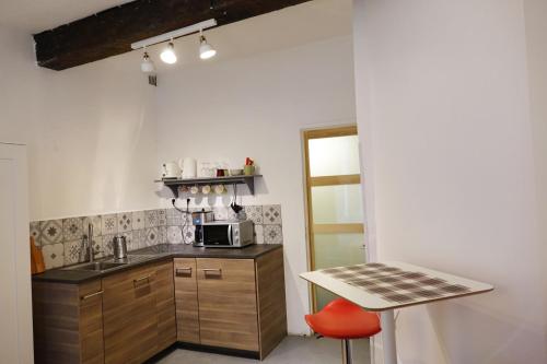 uma cozinha com um balcão e uma mesa e uma mesa em Studio charmant intra-muros em Avignon