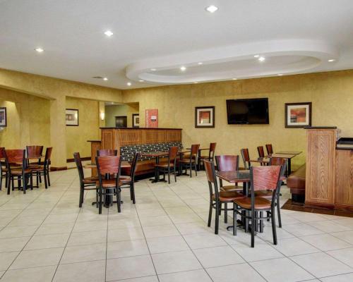 a dining room with tables and chairs and a television at Comfort Inn & Suites in Alvarado