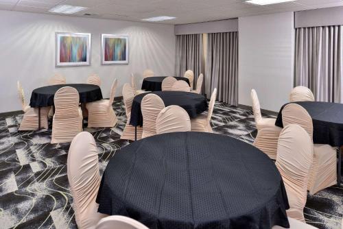 a conference room with black tables and white chairs at Comfort Inn & Suites Frisco - Plano in Frisco