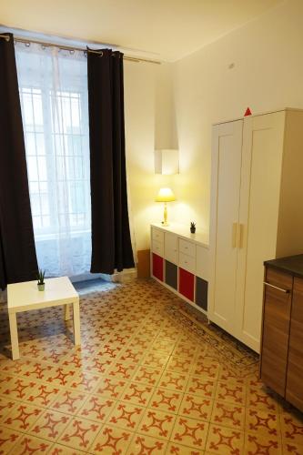 un salon avec une table et une grande fenêtre dans l'établissement Studio charmant intra-muros, à Avignon