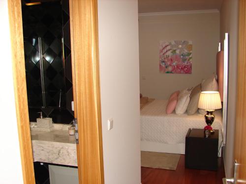 カニコにあるGarajau Eliteのベッドルーム1室(ベッド1台、ランプ付きテーブル付)