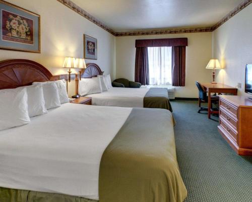 ein Hotelzimmer mit 2 Betten und einem Schreibtisch in der Unterkunft Quality Inn & Suites - Glen Rose in Glen Rose