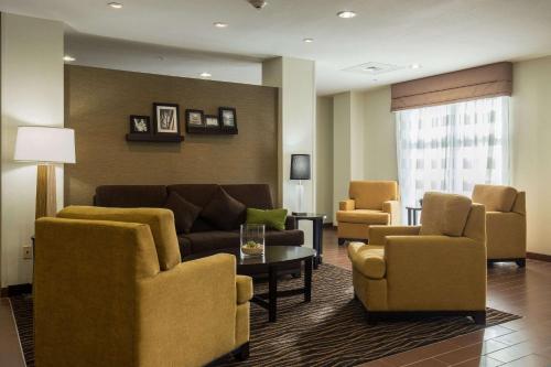 a living room with a couch and chairs and a table at Sleep Inn & Suites Ingleside - Corpus Christi in Ingleside
