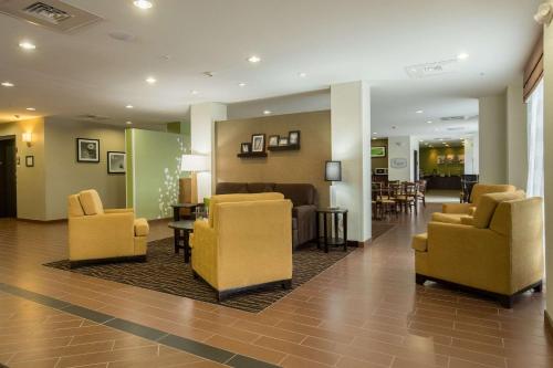 a lobby with yellow chairs and a waiting room at Sleep Inn & Suites Ingleside - Corpus Christi in Ingleside